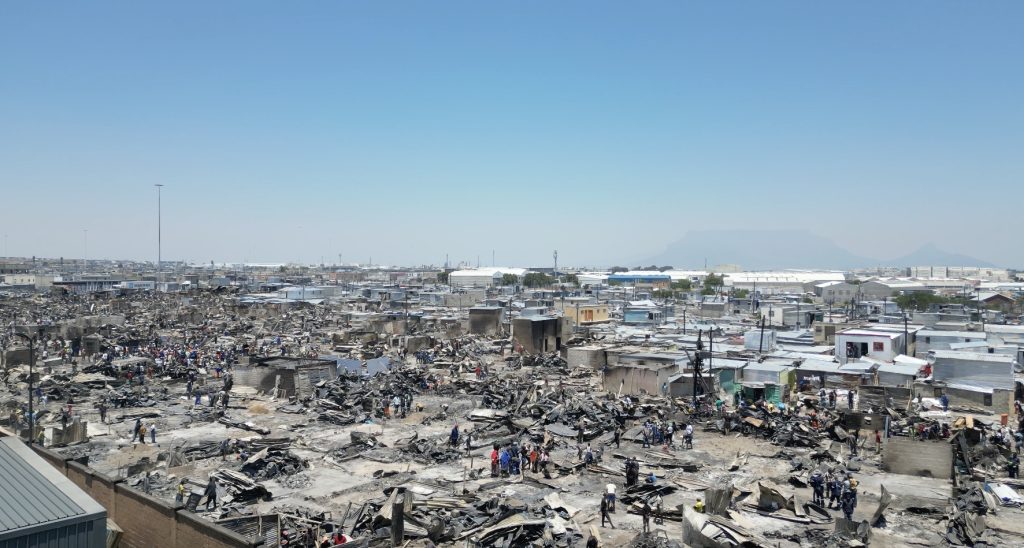 Residents sift through burnt debris and begin rebuilding homes at Doornbach informal settlement after a fire destroyed more than 600 structures.