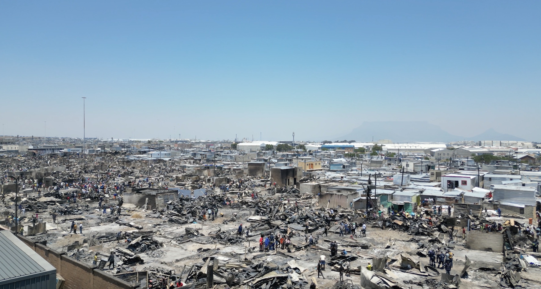 Residents sift through burnt debris and begin rebuilding homes at Doornbach informal settlement after a fire destroyed more than 600 structures.